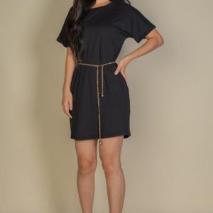 Woman wearing a relaxed fit mini dress with dropped shoulder sleeves and a gold chain belt accent. Her Thread apparel.
